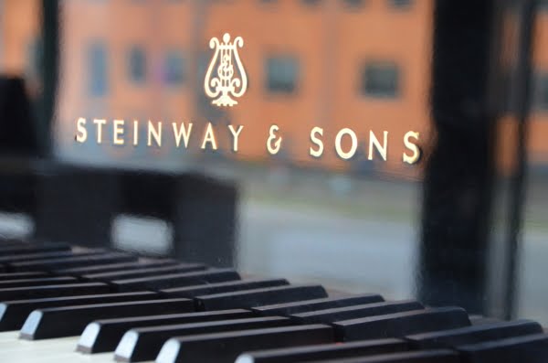 Steinway & Sons logo over tangenter på sort flygel